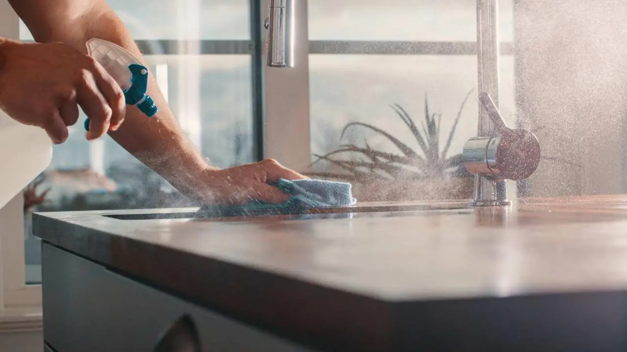 Eine Arbeitsfläche wird eingesprüht und abgewischt
